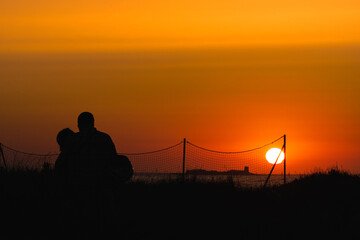 Pareja viendo atardecer en la playa
