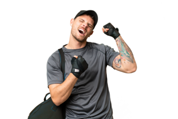 Young sport man with sport bag over isolated chroma key background celebrating a victory