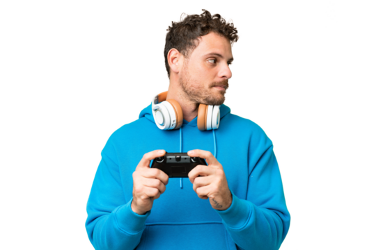 Brazilian man playing with a video game controller over isolated chroma key background looking to the side