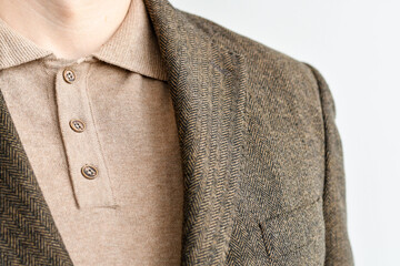 Close up of men casual outwear, dark brown tweed blazer combined with light beige polo.  Selective focus.