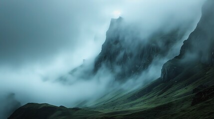 A beautiful landscape image of a mountain covered in fog.