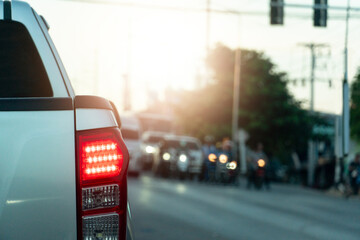 Rear side view of pickup car. Stop and turn on brake light on asphalt road. Stopped at a traffic...