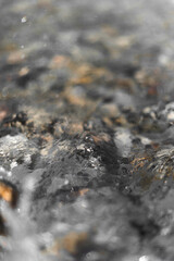 Textura de agua sobre orilla de rocas en la playa