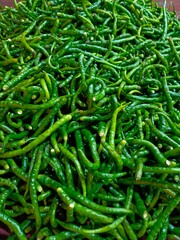pile of green chilies in a traditional market