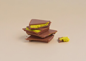pieces of trendy Dubai style chocolate with pistachio on the beige background