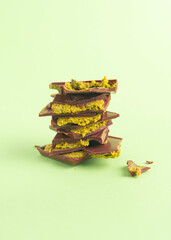 stuck of trendy Dubai style chocolate with pistachio on the green background