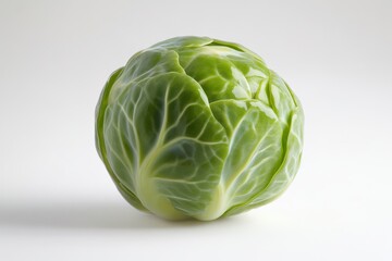 Fototapeta premium A fresh Brussels sprout with vibrant green leaves, showcasing its intricate leaf structure on a light background.