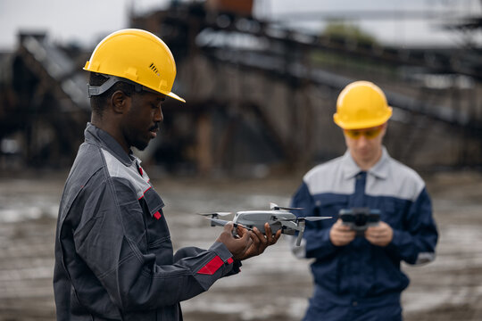 Two engineers african american mans Using uav drones for monitoring sand quarry operations and surveying engineering