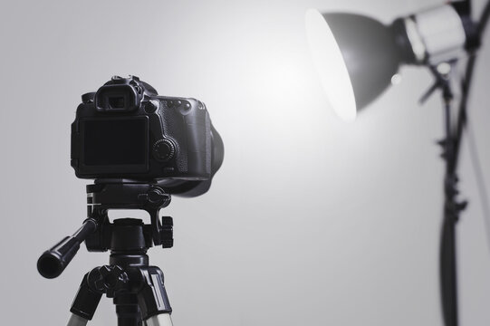 DSLR camera mounted on a tripod in a photography studio setup - Powered by Adobe