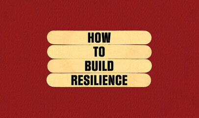 How to Build Resilience Symbol. Concept word How to Build Resilience on beautiful wooden stick. Beautiful Red Chart Paper Background. Business and How to Build Resilience concept. Copy space