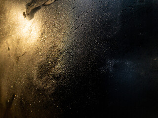 Frost patterns on glass illuminated by a warm, orange light.