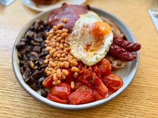 Full english breakfast with crispy bacon and sunny side up eggs is served