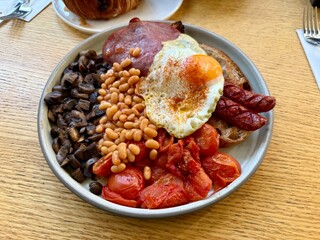 Full english breakfast with crispy bacon and sunny side up eggs is served