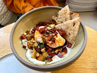 Turkish eggs Cilbir and fresh pita bread for traditional Turkish breakfast served on plate