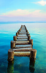 Fototapeta premium Pier Perspective: A solitary pier extends into the tranquil turquoise waters, framed by a serene sky with delicate hues, inviting contemplation and introspection. 