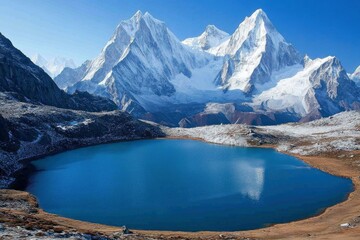 Majestic snowy mountains reflected in a serene blue lake under a clear sky, showcasing nature's beauty