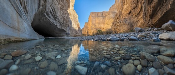 Serene River Flowing Through Majestic Canyon Landscape with Reflections and Clear Blue Sky