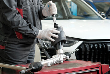 Car service.Repair of the undercarriage of the car.An auto mechanic prepares the replacement of the...