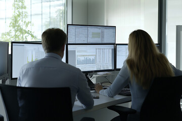 
A group of employees working together on a business project, sharing ideas and screens