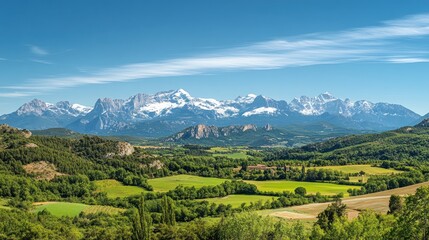 Obraz premium Majestic snow capped mountains overlook a verdant valley landscape