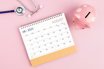 August 2025 desk calendar and stethoscope with piggy bank, Savings for Health insurance.