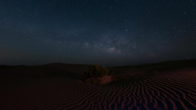 4kTime lapse of milky way night sky in sand dune desert, tilting camera up, empty quarter.