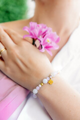 Woman's hand with wrist bracelet, bracelet with natural stones, handmade jewelry, gift idea for a woman, artistic gel nails, smooth hand skin.