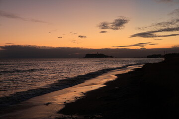 鎌倉・七里ヶ浜海岸から見る江ノ島とオレンジ色になる夕陽とのある風景　夕景