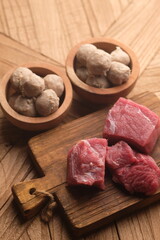 beef meatballs in a wooden bowl and raw beef. raw minced beef. 