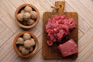 beef meatballs in a wooden bowl and raw beef. raw minced beef. 