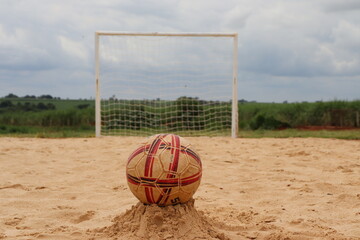 Sand field for beach soccer practice, with a ball positioned in front of the goal.