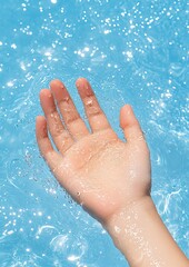Fototapeta premium Pain from sport and fitness Hand reaching into refreshing blue water.