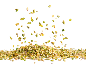 A pile of chopped pistachio nuts with some pieces floating above.