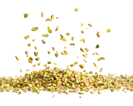 A pile of chopped pistachio nuts with some pieces floating above.