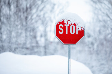 Stop sign covered with snow, concept for stopping the action, cold climate