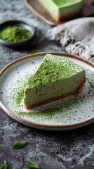 A slice of matcha cheesecake with a dusting of green tea powder on a ceramic white plate, vertical