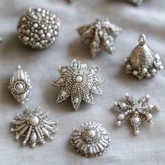 Silver beaded ornaments in various intricate shapes, shimmering elegantly on a soft neutral background
