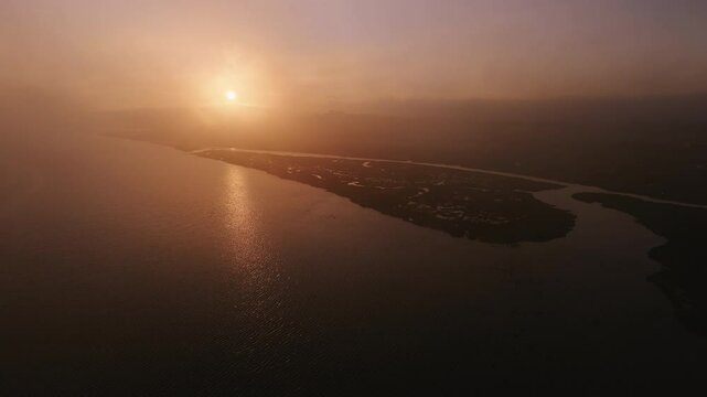 Aerial dawn view over River Taw estuary in a mist. Flocks of birds flying in North Devon, England