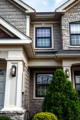 Modern Stone House Exterior: Architectural Design and Landscaping.  Luxury home with gray brick facade, large windows, and stylish entrance. Real estate photography.