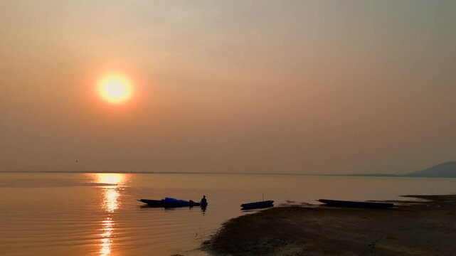 Fisherman on boat river sunset - Asia fisherman net using on wooden boat casting net sunset or sunrise in the Mekong river