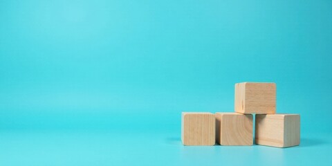 Obraz premium Simple Wooden Cubes on a Blue Background A Minimalist Composition for Design and Creativity