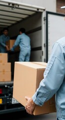 Skilled movers unloading or loading cardboard boxes from a truck, organized and dependable for professional packing, transportation and relocation services for any destination