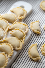 Fresh homemade dumplings prepared on a marble board, showcasing traditional handmade craftsmanship. Raw dough filled with savory ingredients, ready for cooking.