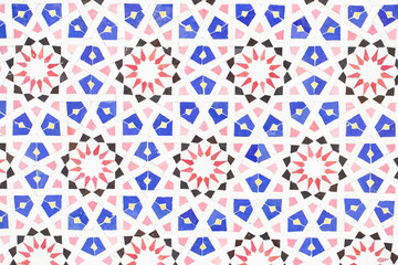 A detailed Islamic geometric mosaic featuring vibrant colors and symmetrical patterns. The design showcases traditional arabesque motifs with star shapes and interwoven lines