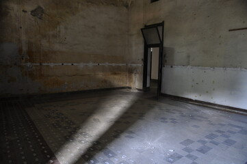 View of an abandoned room ruined with play of light from the window.