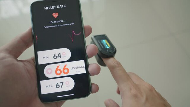 A person using a mobile device to measure heart rate. The screen displays minimum, average, and maximum heart rate statistics, emphasizing the importance of tracking fitness and health metrics.