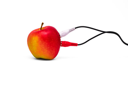 A red apple with a red and white RCA cable attached to it against a white background