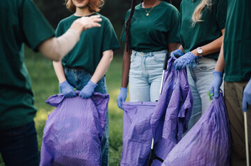 Group of volunteers picking up trash in park