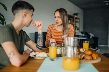 Lesbian couple having a serious conversation during breakfast at home