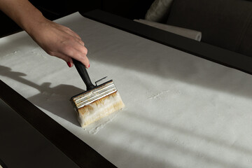 Applying thick glue to wallpaper, brushing wallpaper before sticking it to the wall,